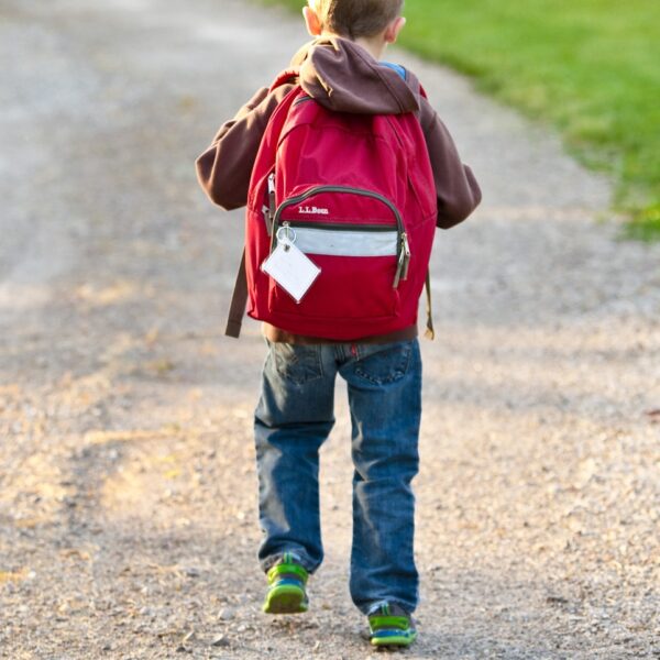 Boy walking away with backpack on road in Nashville, TN