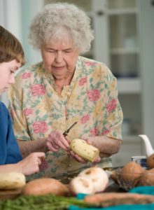 Elderly woman cooking with her grandson