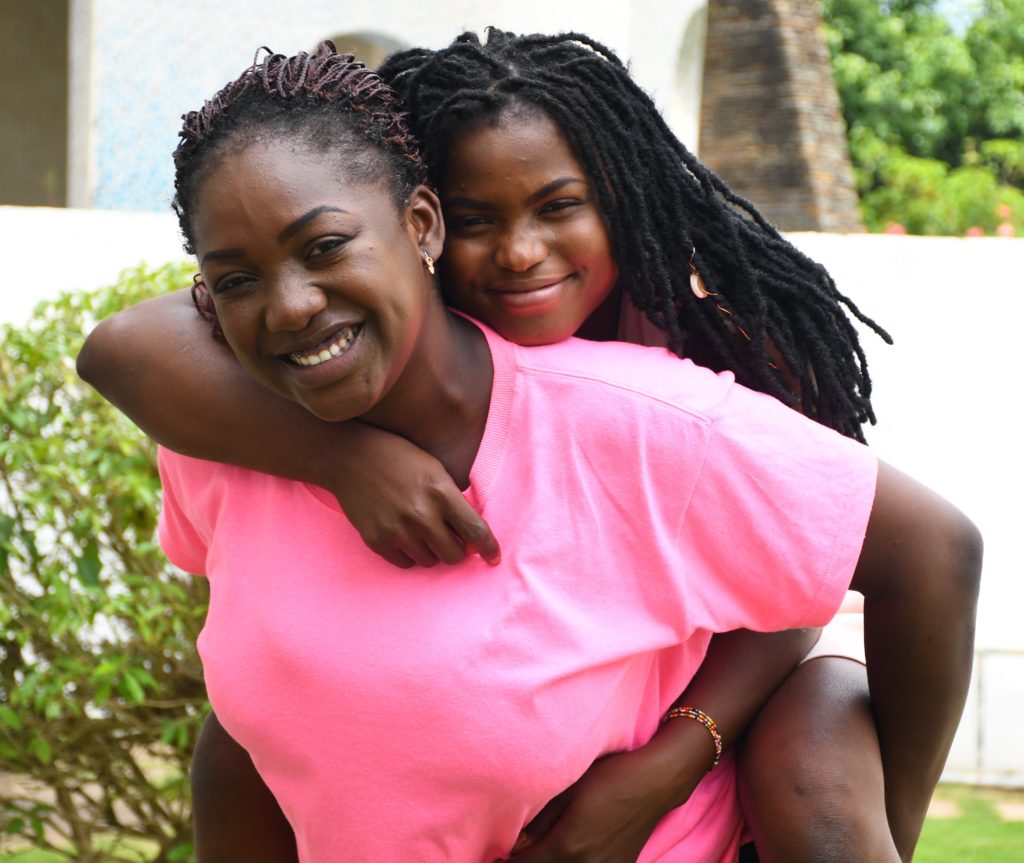 Daughter on mother's back smiling and laughing