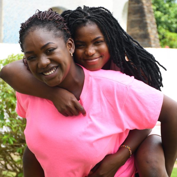 Daughter on mother's back smiling and laughing