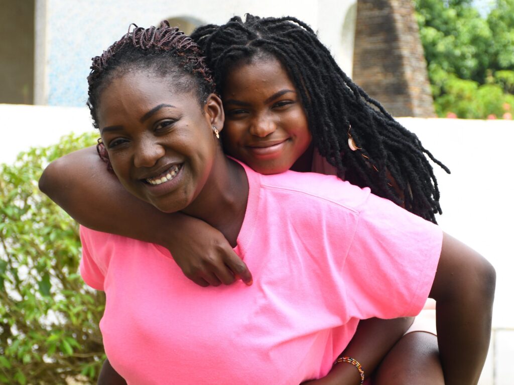 Daughter on mother's back smiling and laughing