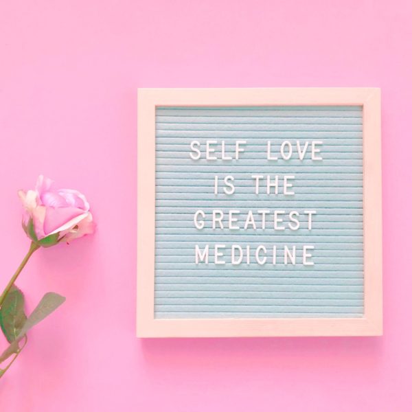 Self Love Message on a board accompanied by a pink rose